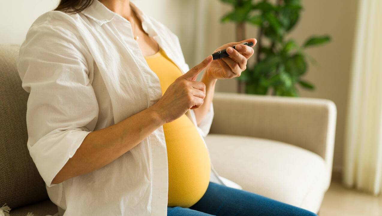 Pregnant woman testing blood sugar