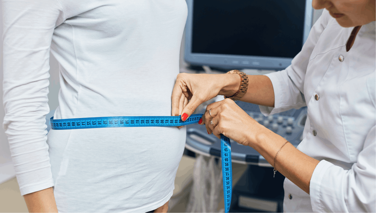 doctor measuring woman's stomach with tape measure